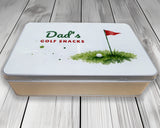 Personalised golf snack tin with "Dad's Golf Snacks" lid, front view on wooden boards