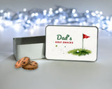 Personalised golf treat tin for Dad or Grandad with the lid standing upright beside the open tin and biscuits, watercolour flag and ball design