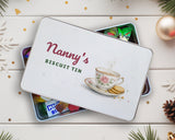 Biscuit tin personalised with a name, lid resting on a tin of wrapped sweets on a festive table